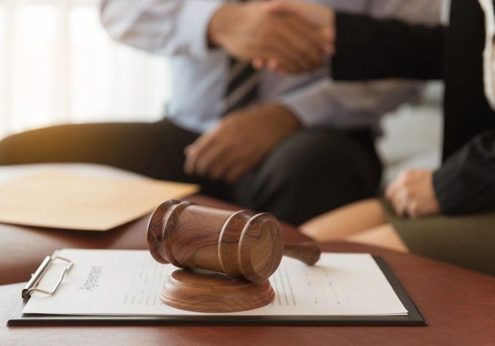 A judge 's gavel sitting on top of papers.